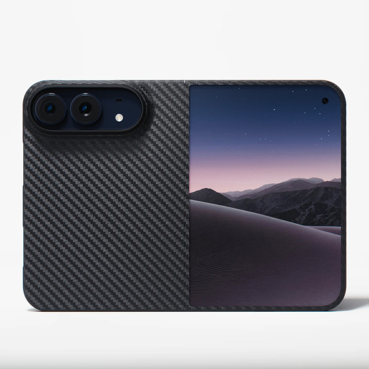 A protective phone case featuring a split design: one half is a dark gray carbon fiber pattern, and the other half displays a scenic wallpaper of purple and blue desert dunes under a starry night sky. The case is shown on a clean white background.