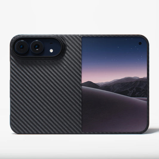 A protective phone case featuring a split design: one half is a dark gray carbon fiber pattern, and the other half displays a scenic wallpaper of purple and blue desert dunes under a starry night sky. The case is shown on a clean white background.